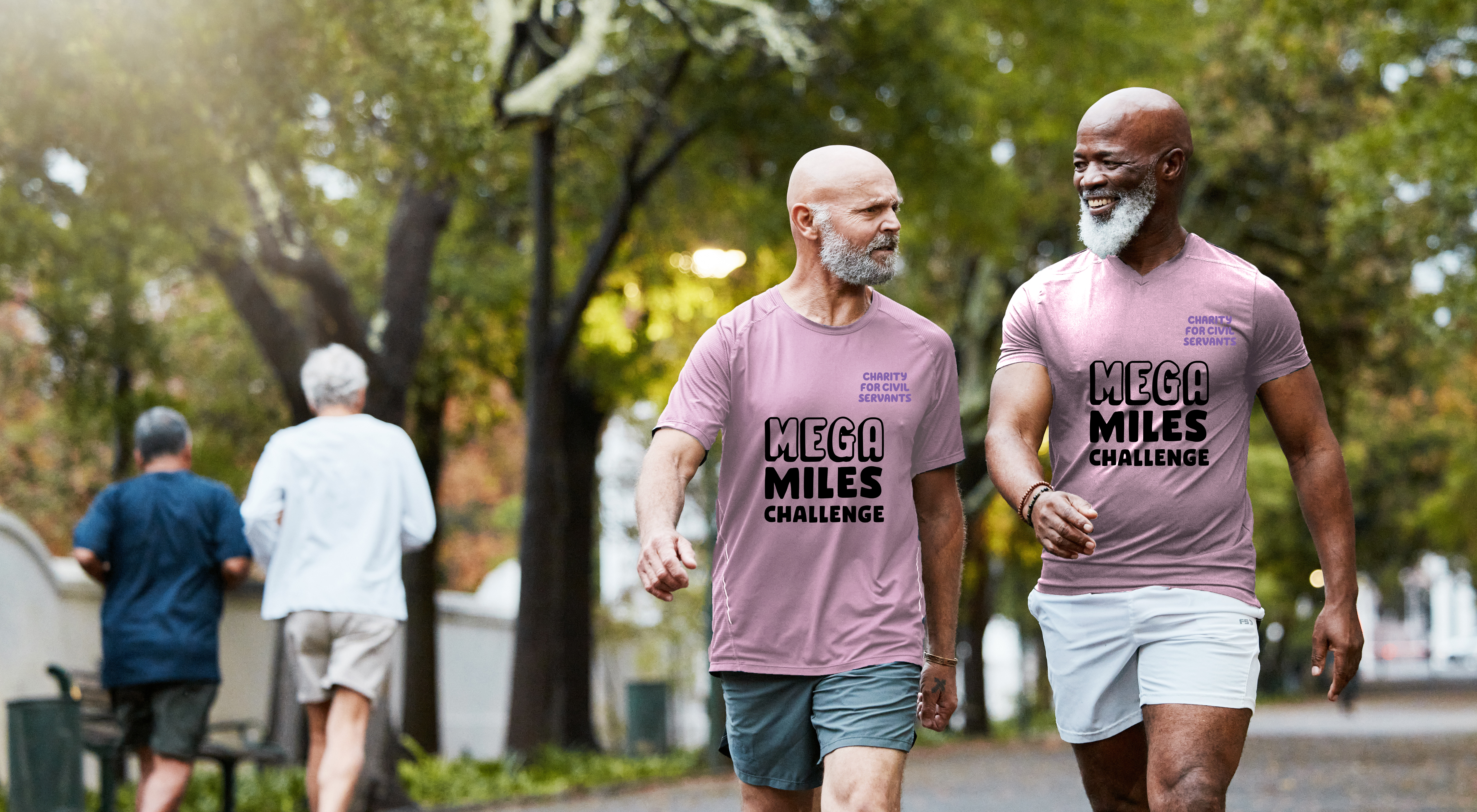 Two men wearing Mega Miles Challenge tshirts walking through a park